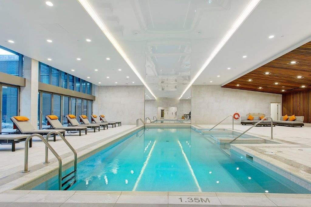 Indoor swimming pool with lounge chairs.